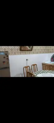 a dining room with a table and chairs and a refrigerator at Taman Mas Falim in Gua Sai