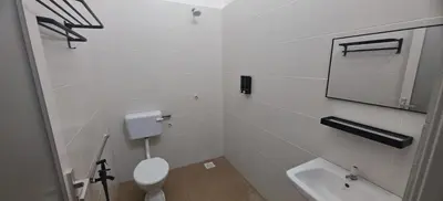 a white bathroom with a toilet and a sink at ZARI Homestay Kamunting in Gua Sai