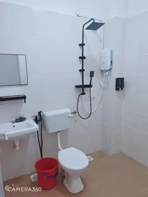a bathroom with a shower and a toilet and a sink at ZARI Homestay Kamunting in Gua Sai