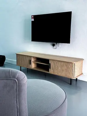 a flat screen tv sitting on top of a wooden entertainment center at Santorini Canning Garden in Ipoh