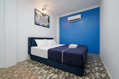 a bed in a room with a blue wall at BOSS Hotel in Ipoh