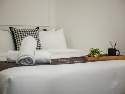 a bed with towels and plants on top of it at 22 Macalisterz by MyKey in George Town