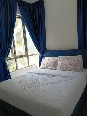 a bedroom with a bed with blue curtains and a window at Ereens homestay Cameron highland in Brinchang