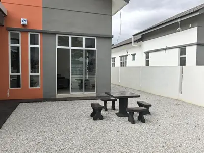 a picnic table and benches in front of a building at Padang Serai Wangi Homestay 55 in Gua Sai