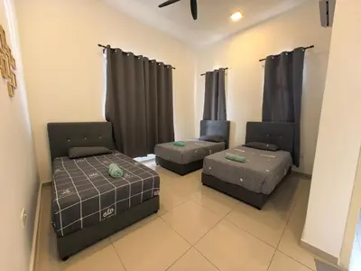 a living room with two beds and a couch at Padang Serai Wangi Homestay 63 in Padang Serai