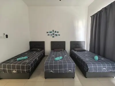 two beds sitting in a room with curtains at Padang Serai Wangi Homestay 63 in Padang Serai