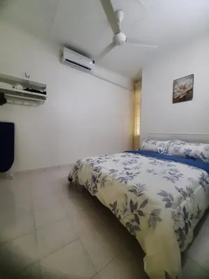 a bedroom with a bed with a blue and white comforter at Cozy AiZHome in Balik Pulau