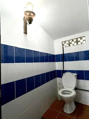 a bathroom with a toilet and blue and white tiles at Bali Nordic American Guest House Style By Nest at Beach St George Town Penang in George Town