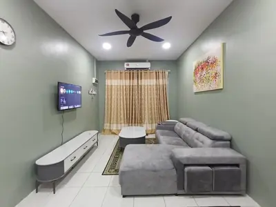 a living room with a couch and a ceiling fan at Teratak Arissa Homestay in Sitiawan