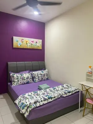 a bedroom with a bed with a purple wall at Teratak Arissa Homestay in Sitiawan