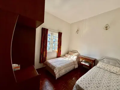 a bedroom with two beds and a window at A Highland Retreat in Tanah Rata in Tanah Rata