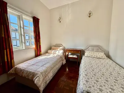 two beds in a room with a window at A Highland Retreat in Tanah Rata in Tanah Rata