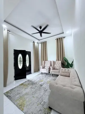a living room with a couch and a ceiling fan at Aisyah Homestay in Kuala Ketil