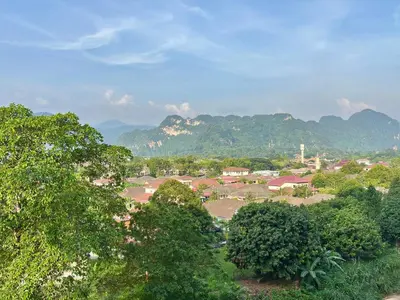 a small town with trees and mountains in the background at The Cove Hillside Residence Ipoh by PLY Home in Ipoh
