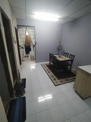 a living room with a table and a cat sitting on the floor at Ed 02 manjung in Seri Manjung
