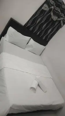 a black and white photo of a bed with a pillow at Dynamic smartstay in Ipoh