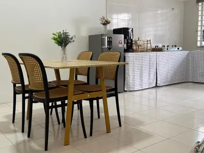 a table and chairs in a kitchen with a counter at 28 Harmoni Homestay, Kamunting in Kamunting
