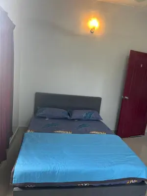 a bed in a bedroom with a blue comforter at Chengai Homestay in Sungkai