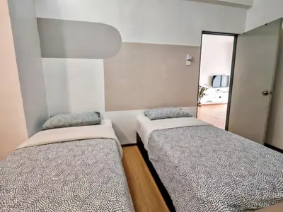 two beds in a small room with a mirror at DawnBlue Cameron Highlands in Brinchang