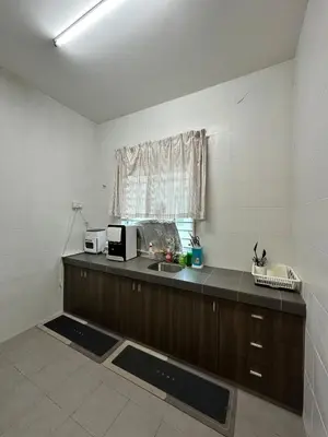 a kitchen with a counter and a sink and a window at Nameera Stay Bandar Universiti Seri Iskandar in Seri Iskandar