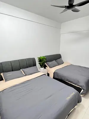 two beds in a room with a ceiling fan at FY Perumahan Makmur TR Jaya Tanah Rata in Tanah Rata