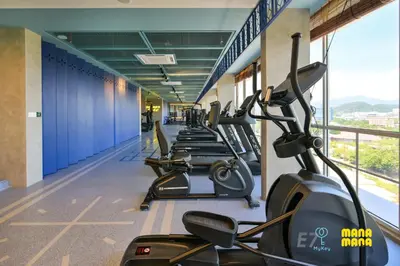 a row of treadmills in a gym with a row of bikes at Stallionz by MyKey in Ipoh