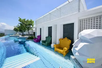 a swimming pool with chairs next to a house at Stallionz by MyKey in Ipoh