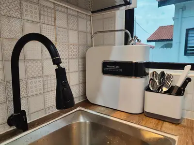 a kitchen counter top with a sink and a kitchen mixer at Arjuna Homestay - Batu Gajah in Batu Gajah