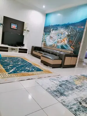 a living room with a couch and a flat screen tv at Homestay Ustaz in Batu Gajah