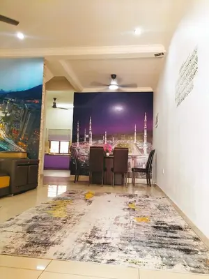 a dining room with a large painting on the wall at Homestay Ustaz in Batu Gajah