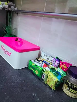 a pink lunch box sitting next to some food at Homestay Ustaz in Batu Gajah