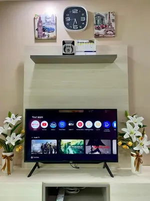 a flat screen tv in a living room with a clock at Syahoney Homestay 2 with NETFLIX in Tanah Rata