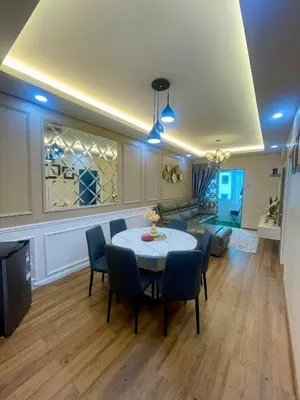 a living room with a table and chairs and a couch at Syahoney Homestay 2 with NETFLIX in Tanah Rata