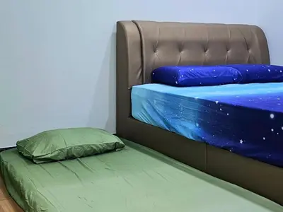 a bunk bed with a green mattress and blue sheets at Sekinchan Family-style XL Size Homestay in Sekincan