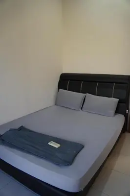 a bed with a blue blanket on top of it at Wewe Homestay in Kampung Gajah