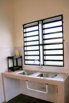 a kitchen with a sink and a large window at Wewe Homestay in Kampung Gajah