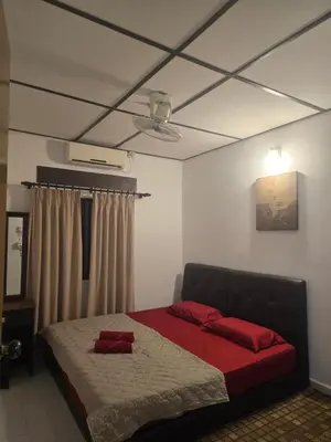 a bedroom with a bed with red pillows on it at D Tasek Homestay Lenggong