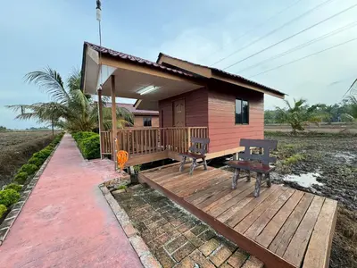 a small house with a deck and a bench at Akira Laman Padi Tg Karang in Tanjung Karang