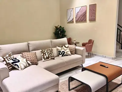 a living room with a couch and a table at Warm & Cozy Home in Kampong Duson Gilap