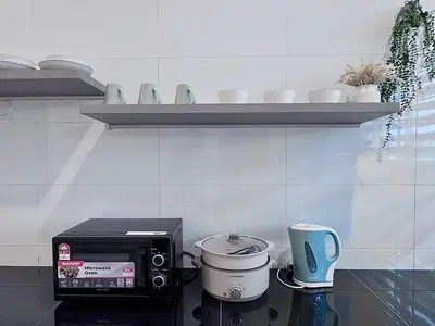a kitchen counter with a toaster oven and a coffee pot at Warm & Cozy Home in Kampong Duson Gilap
