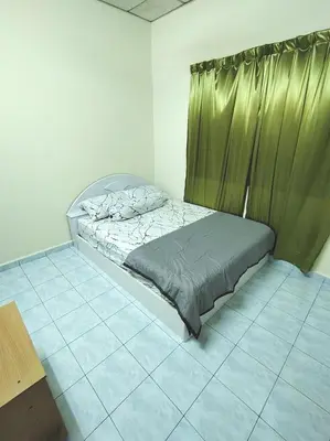 a bed in a room with a green curtain at D'Manjung Samudera Baru HomeSTAY in Seri Manjung