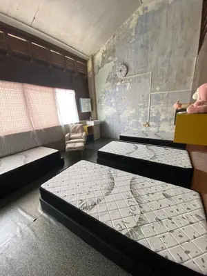 a room with three beds and a wall with a map at Bitterswiit Ladies Hostel in George Town