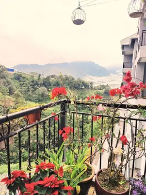a balcony with red flowers and a view at #MyHighlandGetaway at OmniCassia Cameron Highlands in Cameron Highlands