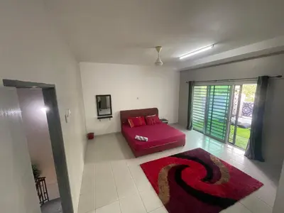 a living room with a red couch and a red rug at MieMar Homestay Gopeng in Gopeng