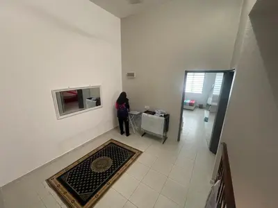 a woman standing in a room with a television at MieMar Homestay Gopeng in Gopeng