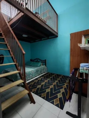 a bedroom with a bunk bed and a spiral staircase at Homestay Sakinah No 39 in Tanjung Malim