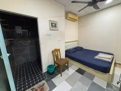 a small bedroom with a bed and a shower at Ray Yan Guesthouse Penang in Batu Ferringhi