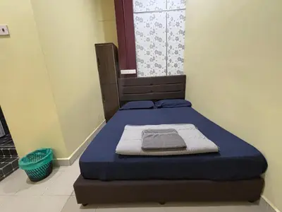 a bed in a room with a blue mattress and a window at Ray Yan Guesthouse Penang in Batu Ferringhi