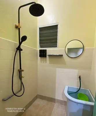 a bathroom with a shower with a toilet and a mirror at Homestay Ayah Iz Temerloh Jaya in Gua Sai