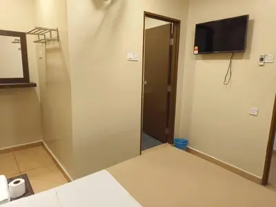 a room with a door and a television on the wall at The Pines Hotel in Tanah Rata